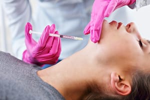Attractive young woman gets cosmetic face injection