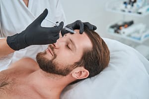 Spa client getting a dermal filler injection into the forehead