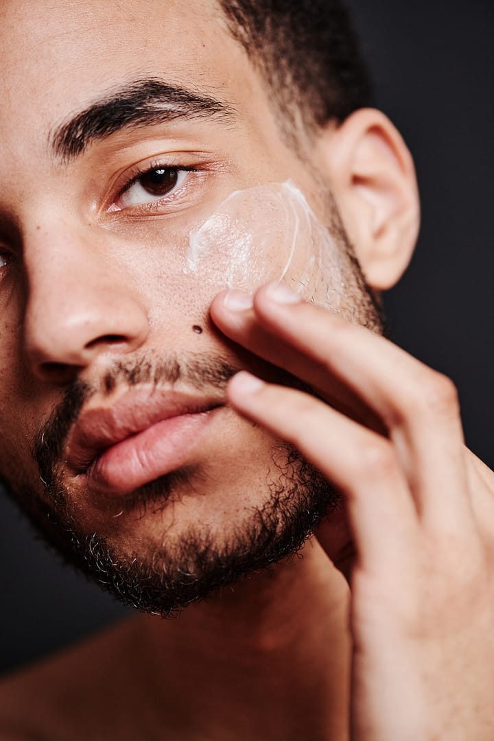 Young man applying face cream